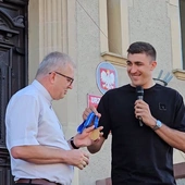 Łukasz Kaczmarek przekazuje złoty medal na ręcę proboszcza bazylikii w Krotoszynie